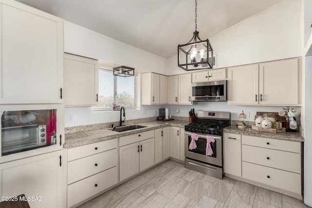 kitchen with light countertops, a chandelier, appliances with stainless steel finishes, a sink, and pendant lighting