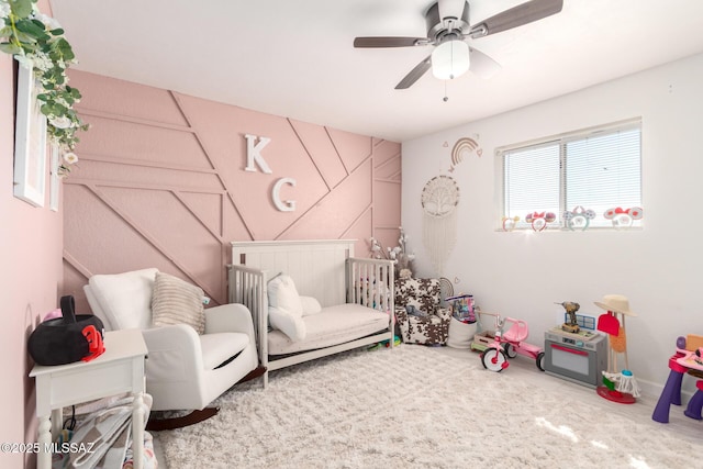 bedroom featuring a crib and a ceiling fan