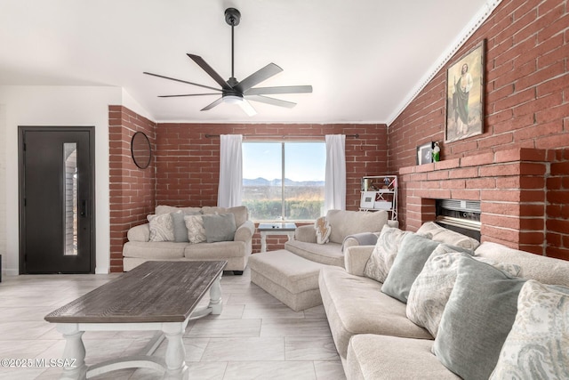 living room with a fireplace, ceiling fan, brick wall, and vaulted ceiling