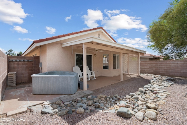 4654 W Gatehinge Ct, Tucson, AZ 85741 - back of property featuring a ceiling fan, a hot tub, a fenced backyard, and stucco siding