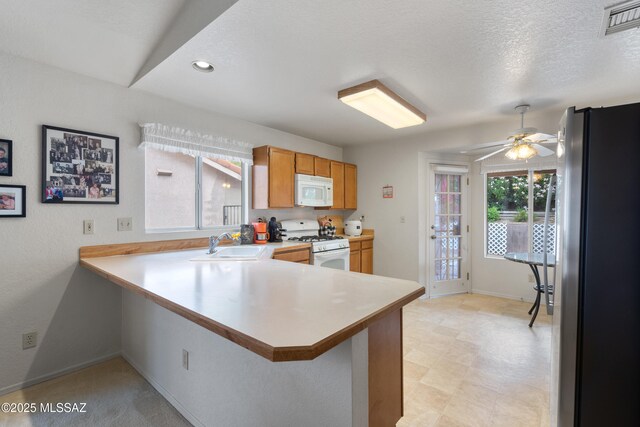 4654 W Gatehinge Ct, Tucson, AZ 85741 - kitchen featuring white appliances, a sink, ceiling fan, light countertops, and a peninsula