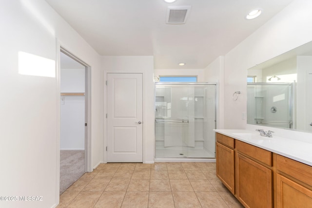 6866 E Via Arroyo Largo, Tucson, AZ 85756 - bathroom with a shower stall, tile patterned floors, vanity, a walk in closet, and recessed lighting