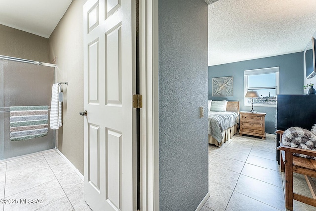 interior space with tile patterned flooring, a textured wall, and a textured ceiling