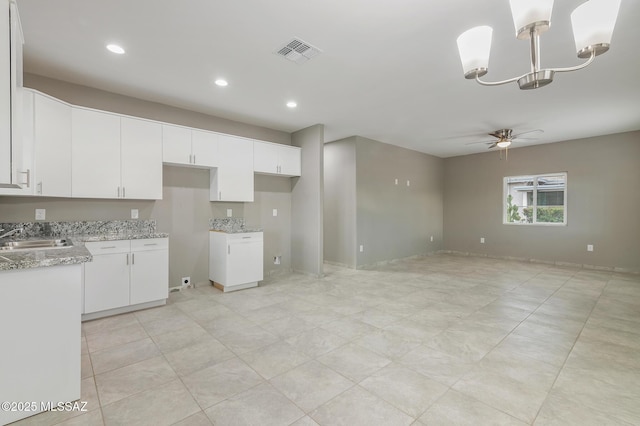 9121 W Claude St, Tucson, AZ 85735 - kitchen featuring visible vents, ceiling fan with notable chandelier, a sink, light stone counters, and white cabinets