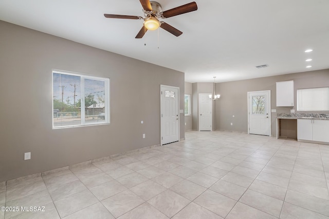 9121 W Claude St, Tucson, AZ 85735 - unfurnished living room featuring recessed lighting, visible vents, light tile patterned flooring, and ceiling fan with notable chandelier