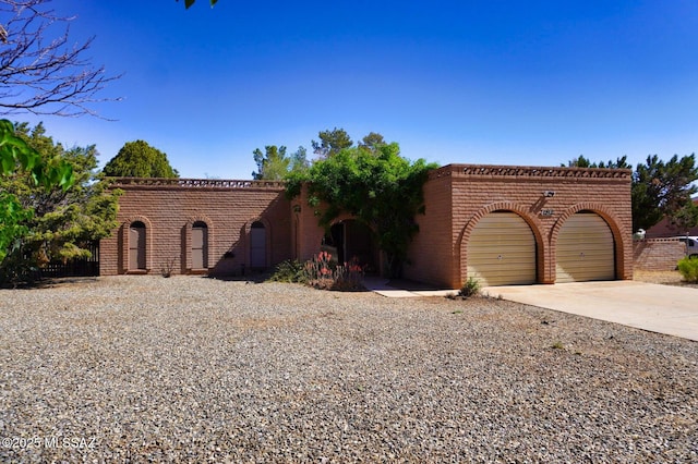 view of front of house with concrete driveway, brick siding, and an attached garage