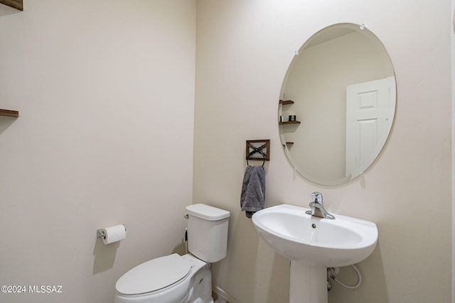half bath featuring a sink and toilet