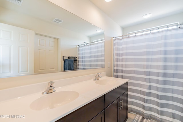 bathroom with double vanity, visible vents, recessed lighting, and a sink