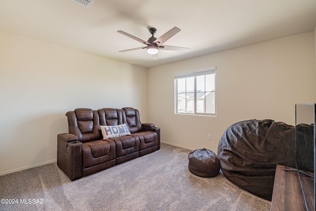 carpeted living area with baseboards and ceiling fan