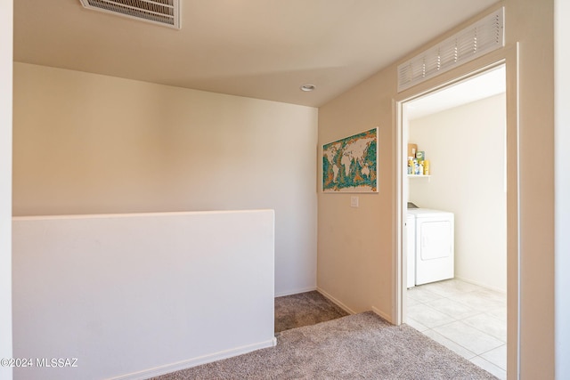 hall with carpet floors, washer and dryer, and visible vents