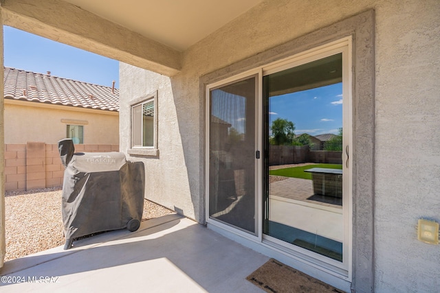 view of patio featuring a grill and fence