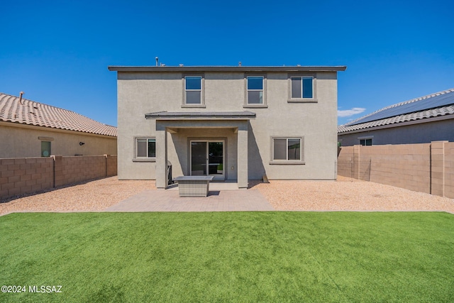 back of property with a lawn, a fenced backyard, a patio, and stucco siding