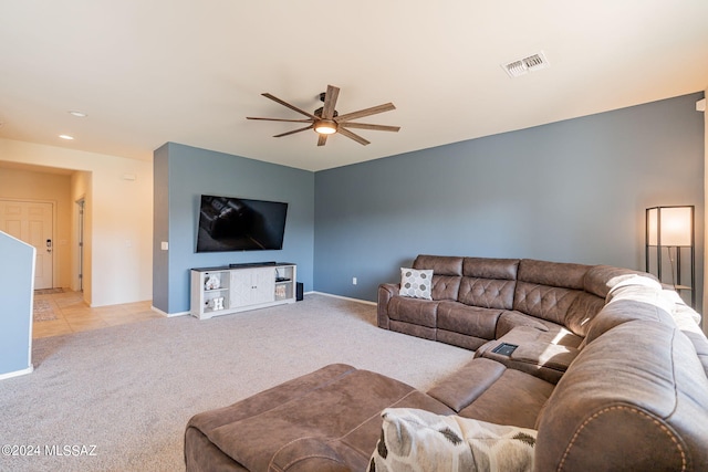 living room with visible vents, baseboards, a ceiling fan, light carpet, and light tile patterned floors