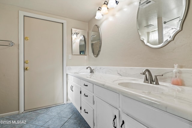 full bath with double vanity, visible vents, a sink, and tile patterned flooring