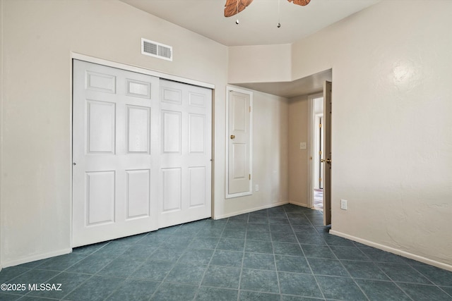unfurnished bedroom with dark tile patterned flooring, baseboards, a closet, and visible vents