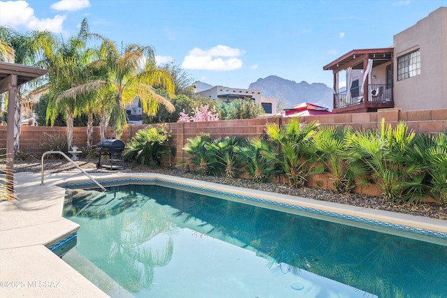 view of swimming pool featuring a fenced in pool, area for grilling, a mountain view, and fence private yard