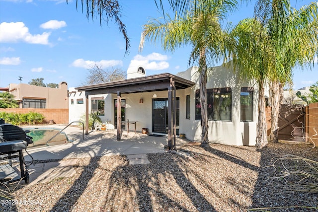 back of house featuring stucco siding, a fenced in pool, a fenced backyard, and a patio area