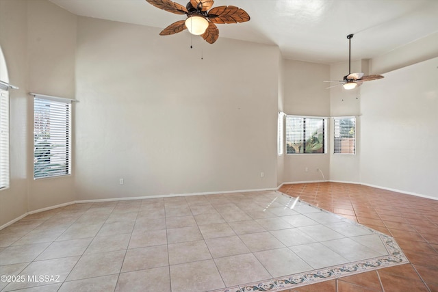 spare room with light tile patterned floors, plenty of natural light, high vaulted ceiling, and ceiling fan