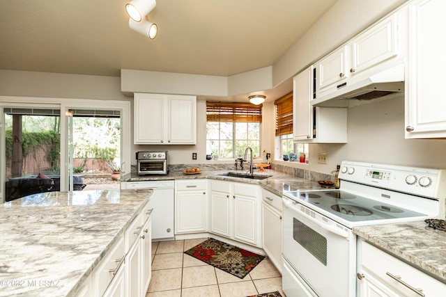 kitchen featuring white cabinets, a sink, white appliances, under cabinet range hood, and light tile patterned flooring