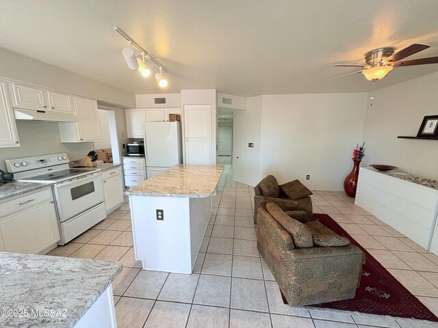 kitchen with white appliances, white cabinetry, a kitchen island, under cabinet range hood, and visible vents