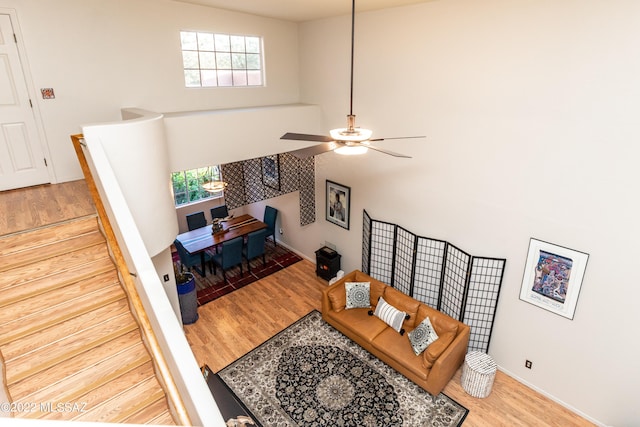 living room with a wealth of natural light, a ceiling fan, and wood finished floors