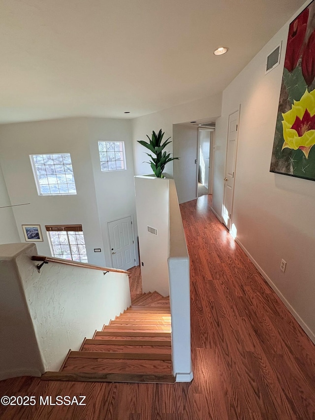 stairway with visible vents, baseboards, recessed lighting, and wood finished floors