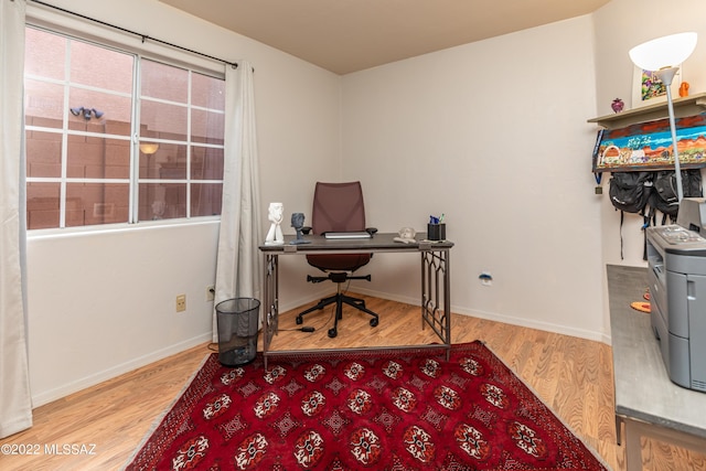 office space with baseboards and wood finished floors