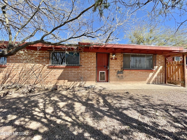 view of front of home featuring brick siding and fence