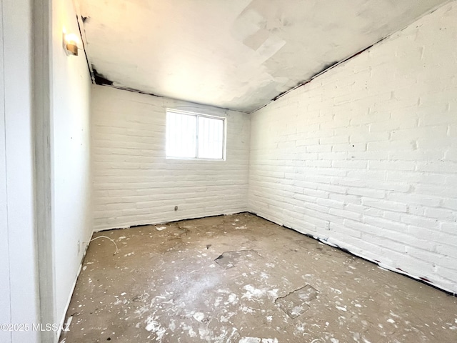 unfurnished room with brick wall
