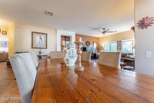 dining room with tile patterned floors, visible vents, and ceiling fan