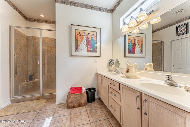 bathroom featuring double vanity, a sink, a shower stall, and visible vents