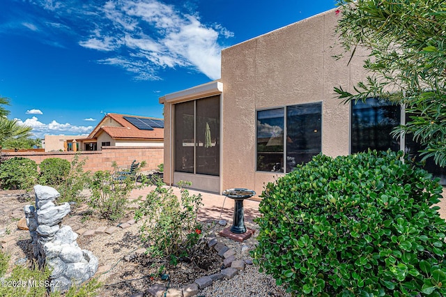 exterior space featuring a sunroom and fence