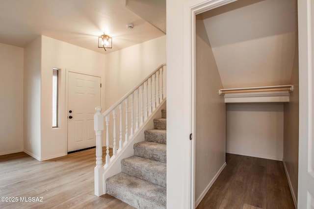 staircase featuring baseboards and wood finished floors