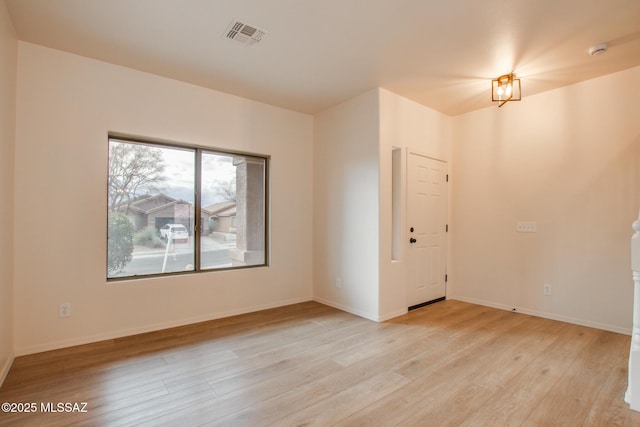 unfurnished room with visible vents, baseboards, and light wood-style flooring