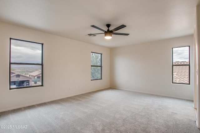 unfurnished room featuring visible vents, carpet floors, baseboards, and ceiling fan