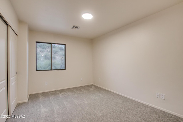 unfurnished bedroom featuring baseboards, visible vents, carpet floors, and a closet