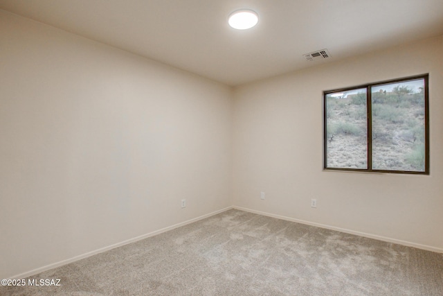 empty room with light colored carpet, visible vents, and baseboards