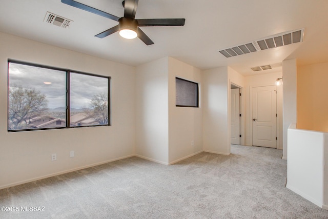 carpeted empty room featuring visible vents, baseboards, and ceiling fan