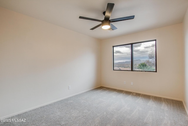 spare room featuring baseboards, carpet, and a ceiling fan