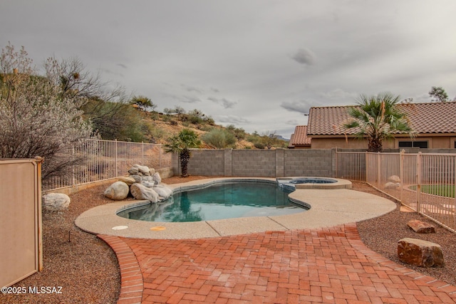 view of swimming pool with a patio area, a pool with connected hot tub, and a fenced backyard