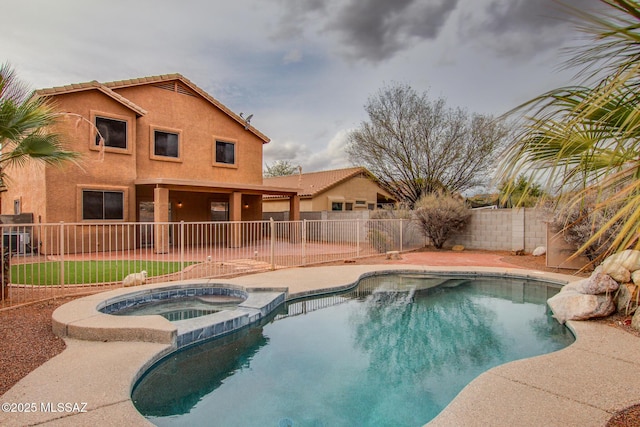 view of pool with a patio area, a pool with connected hot tub, and a fenced backyard