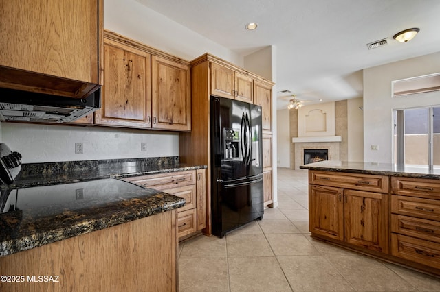420 E Deers Rest Pl, Tucson, AZ 85704 - kitchen featuring black fridge with ice dispenser, a lit fireplace, light tile patterned flooring, ceiling fan, and visible vents