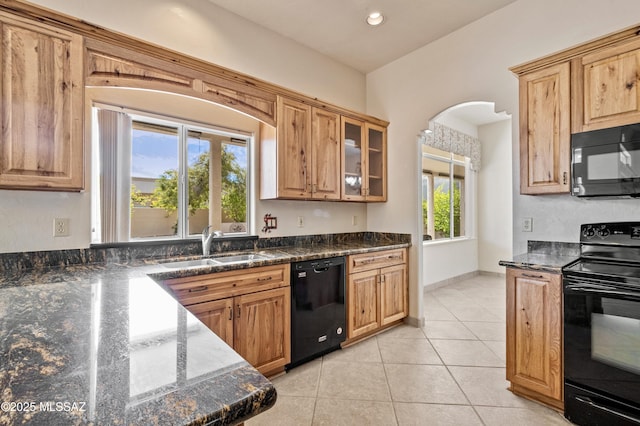 420 E Deers Rest Pl, Tucson, AZ 85704 - kitchen featuring arched walkways, dark stone countertops, a sink, black appliances, and light tile patterned floors