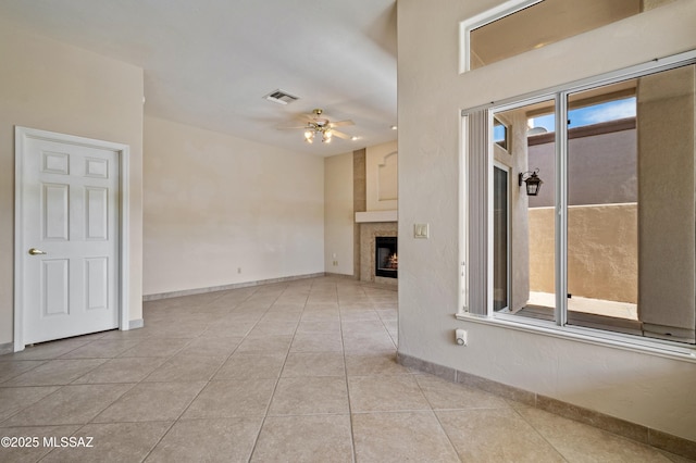 420 E Deers Rest Pl, Tucson, AZ 85704 - tiled empty room featuring baseboards, visible vents, a lit fireplace, and a ceiling fan