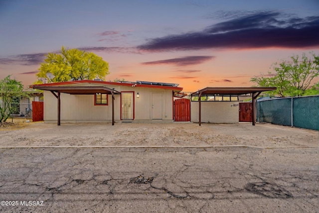 view of front facade with a carport, fence, and a gate