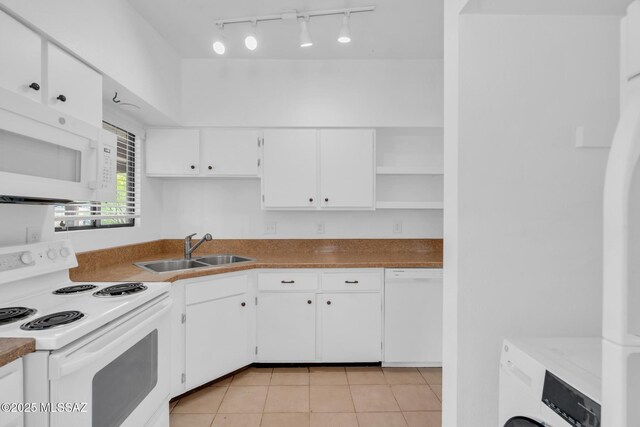 kitchen featuring white appliances, white cabinetry, open shelves, washer / dryer, and a sink