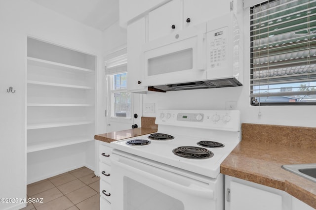 kitchen featuring white cabinets, white appliances, and light tile patterned floors