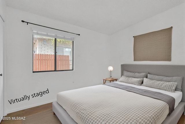 bedroom with baseboards and wood finished floors