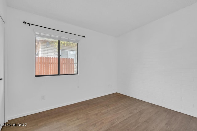 empty room featuring baseboards and wood finished floors