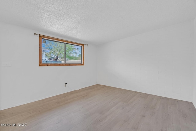 spare room featuring a textured ceiling and wood finished floors